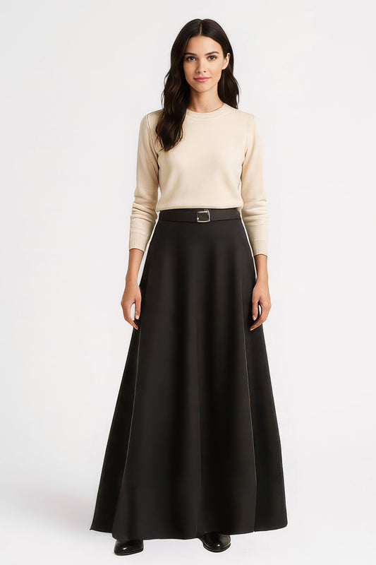 Woman wearing a beige sweater and long black skirt on a white background