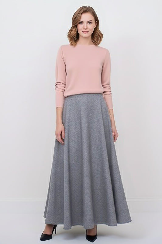 Woman wearing pink sweater and light grey wool maxi skirt